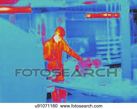 Stock Image - Infra red heat image of worker in factory. Fotosearch