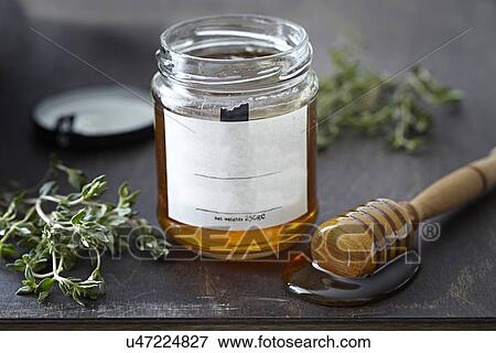 Jar of honey with herbs View Large Photo Image Stock Photo - Jar of honey with herbs. Fotosearch