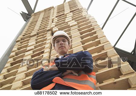 Low angle portrait of young man and tower of pallets in timber yard View Large Photo Image Stock Image - Low angle portrait of young man and tower of pallets in timber yard. Fotosearch