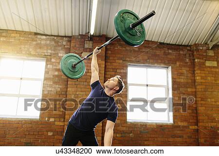 Man lifting barbell with one hand View Large Photo Image Stock Image - Man lifting barbell with one hand. Fotosearch