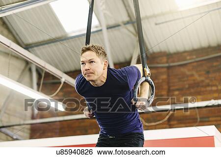 Man pulling suspended rings in gym View Large Photo Image Stock Photograph - Man pulling suspended rings in gym. Fotosearch