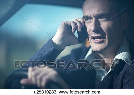 Man using smartphone whilst driving View Large Photo Image Stock Image - Man using smartphone whilst driving. Fotosearch