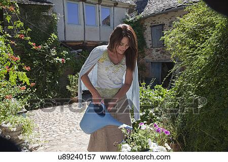 Mature adult woman watering garden plants View Large Photo Image Stock Photo - Mature adult woman watering garden plants. Fotosearch