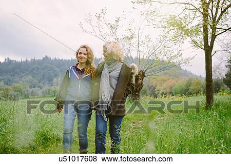 Mature woman and teenage daughter strolling in field View Large Photo Image Stock Photo - Mature woman and teenage daughter strolling in field. Fotosearch