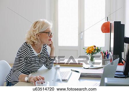 Mature woman at home using computer View Large Photo Image Stock Image - Mature woman at home using computer. Fotosearch