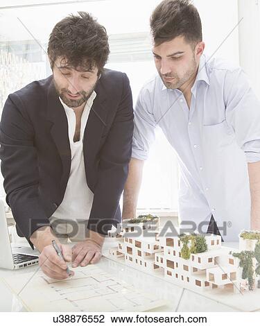 Stock Image - Men looking at architectural plans. Fotosearch