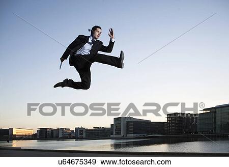 Mid adult businessman jumping mid air, Copenhagen harbor, Denmark View Large Photo Image Stock Photo - Mid adult businessman jumping mid air, Copenhagen harbor, Denmark. Fotosearch