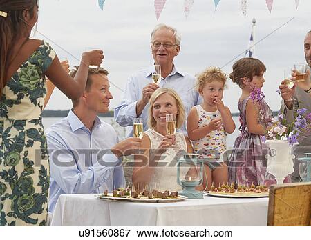 Mid adult couple at wedding reception making a toast with friends View Large Photo Image Stock Photo - Mid adult couple at wedding reception making a toast with friends. Fotosearch