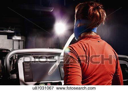 Mid adult female with face mask running on gym treadmill in altitude centre View Large Photo Image Stock Photo - Mid adult female with face mask running on gym treadmill in altitude centre. Fotosearch