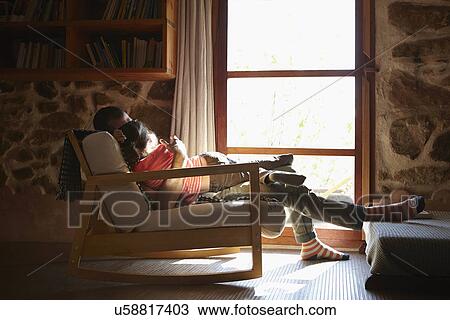 Mid adult man and daughter hugging on rocking chair View Large Photo Image Stock Image - Mid adult man and daughter hugging on rocking chair. Fotosearch