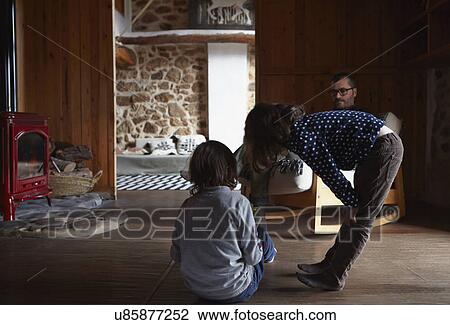 Mid adult man and two children relaxing in sitting room View Large Photo Image Stock Image - Mid adult man and two children relaxing in sitting room. Fotosearch