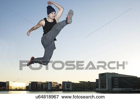 Mid adult man jumping mid air, Copenhagen harbor, Denmark View Large Photo Image Stock Photo - Mid adult man jumping mid air, Copenhagen harbor, Denmark. Fotosearch