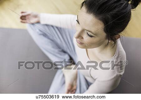 Mid adult woman meditating View Large Photo Image Stock Photo - Mid adult woman meditating. Fotosearch