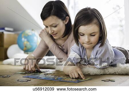 Stock Photo - Mother and daughter doing jigsaw. Fotosearch