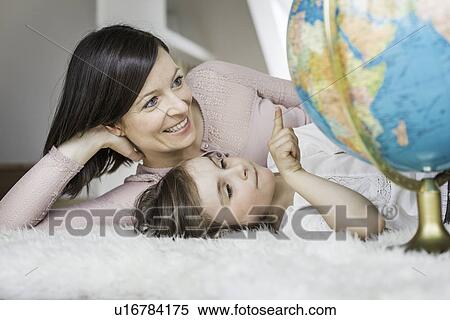 Stock Photography - Mother and daughter looking at globe. Fotosearch