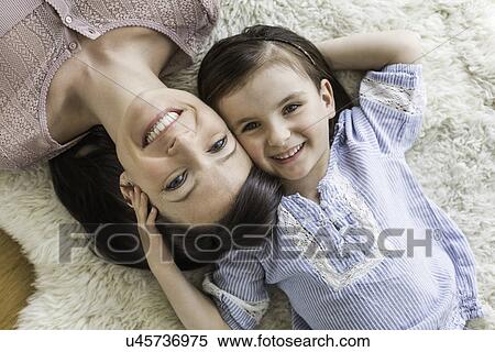 Mother and daughter lying on fur rug, overhead view View Large Photo Image Stock Photography - Mother and daughter lying on fur rug, overhead view. Fotosearch