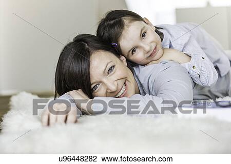 Mother and daughter lying on rug View Large Photo Image Stock Image - Mother and daughter lying on rug. Fotosearch