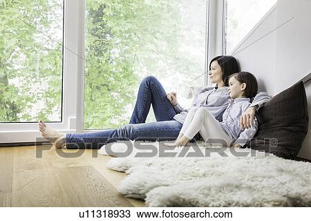 Mother and daughter sitting on fur rug at home View Large Photo Image Stock Image - Mother and daughter sitting on fur rug at home. Fotosearch