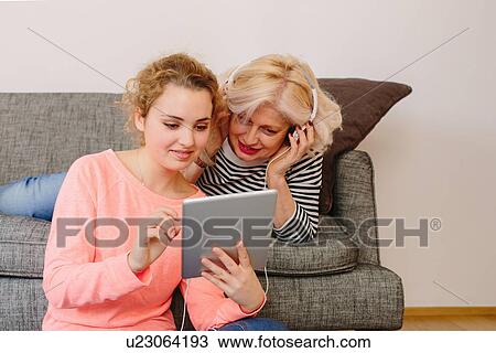 Mother and teenage daughter listening to music from digital tablet View Large Photo Image Stock Image - Mother and teenage daughter listening to music from digital tablet. Fotosearch