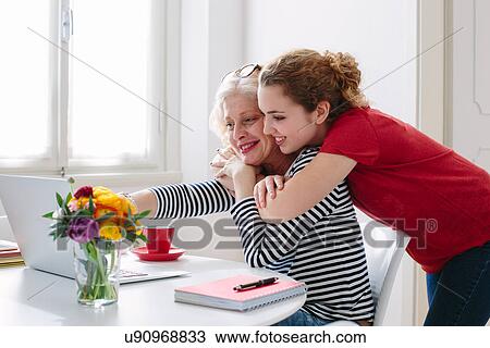 Mother and teenage daughter looking at laptop at home View Large Photo Image Stock Image - Mother and teenage daughter looking at laptop at home. Fotosearch