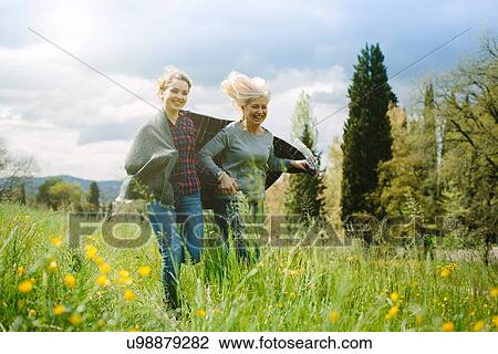 Mother and teenage daughter running wrapped in blanket View Large Photo Image Stock Image - Mother and teenage daughter running wrapped in blanket. Fotosearch