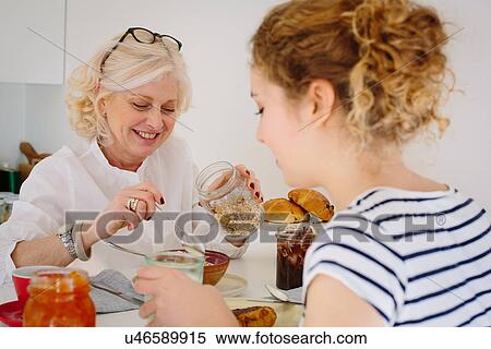 Stock Photography - Mother and teenage daughter sharing breakfast at home. Fotosearch