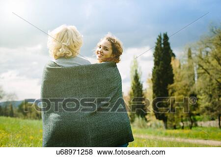Stock Photo - Mother and teenage daughter wrapped in blanket. Fotosearch