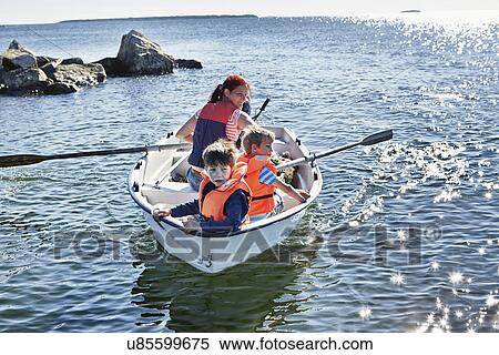 Stock Photography - Mother and two young sons in rowing boat on lake, Gavle, Sweden. Fotosearch