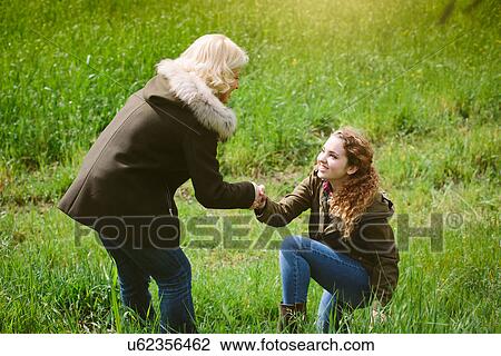 Mother giving teenage daughter a helping hand View Large Photo Image Stock Image - Mother giving teenage daughter a helping hand. Fotosearch