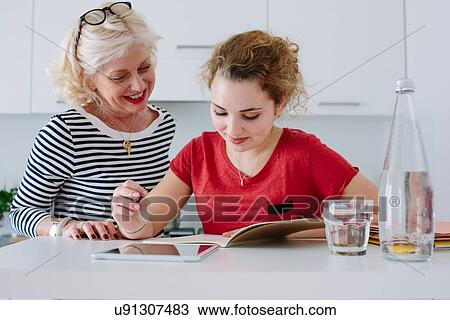 Mother helping teenage daughter with homework View Large Photo Image Stock Image - Mother helping teenage daughter with homework. Fotosearch