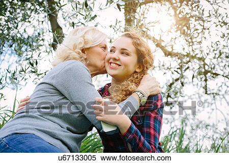 Mother kissing teenage daughter on cheek View Large Photo Image Stock Photography - Mother kissing teenage daughter on cheek. Fotosearch