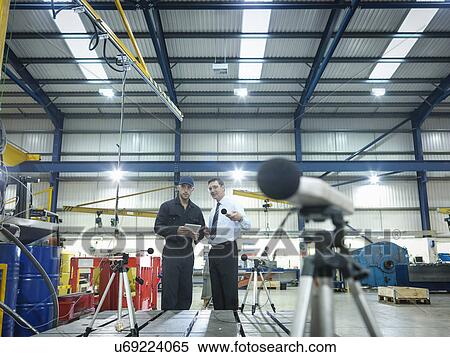 Stock Photography - Office and factory worker checking sound volume in factory. Fotosearch