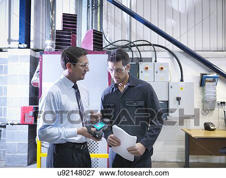 Office manager and worker discuss energy use with infra red camera next to boiler in factory View Large Photo Image Stock Photo - Office manager and worker discuss energy use with infra red camera next to boiler in factory. Fotosearch