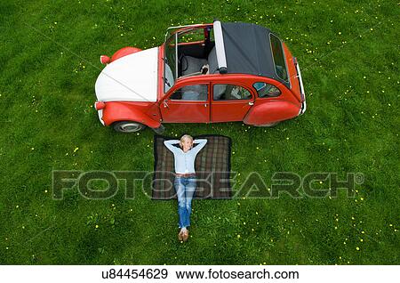 Stock Photo - Overhead view of mature woman relaxing on picnic blanket. Fotosearch