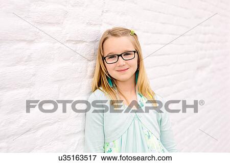 Portrait of cute girl next to white wall View Large Photo Image Stock Photo - Portrait of cute girl next to white wall. Fotosearch