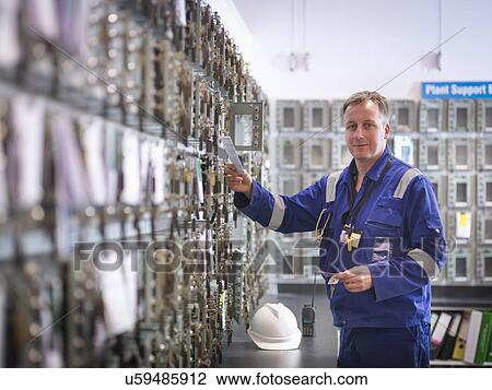 Stock Image - Portrait of engineer selecting equipment keys in power station. Fotosearch