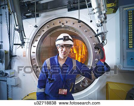 Stock Photo - Portrait of engineer with fuel rod handling machine in nuclear power station. Fotosearch