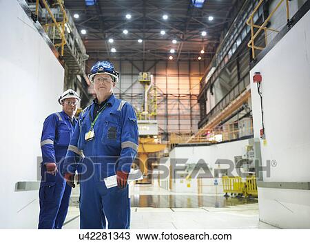 Stock Image - Portrait of engineers in reactor hall in nuclear power station. Fotosearch