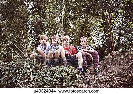 Portrait of four boys sitting in forest View Large Photo Image Picture - Portrait of four boys sitting in forest. Fotosearch