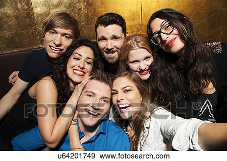 Stock Photo - Portrait of group of male and female friends in nightclub. Fotosearch