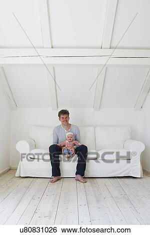 Portrait of mature father with baby daughter on sofa View Large Photo Image Stock Photograph - Portrait of mature father with baby daughter on sofa. Fotosearch