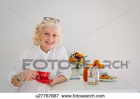 Portrait of mature woman at home having a coffee View Large Photo Image Stock Photo - Portrait of mature woman at home having a coffee. Fotosearch