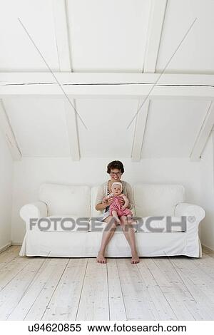 Portrait of mid adult mother with baby daughter sitting on lap View Large Photo Image Stock Photography - Portrait of mid adult mother with baby daughter sitting on lap. Fotosearch