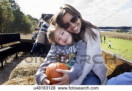 Portrait of mother and son holding pumpkin View Large Photo Image Stock Photo - Portrait of mother and son holding pumpkin. Fotosearch