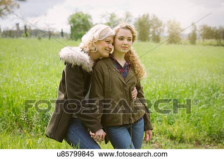 Portrait of mother and teenage daughter holding hands in field View Large Photo Image Stock Photography - Portrait of mother and teenage daughter holding hands in field. Fotosearch