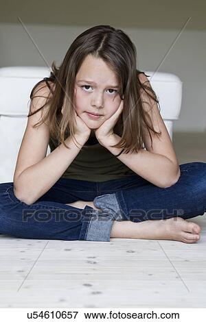 Stock Photo - Portrait of unhappy twelve year old girl with head in hands. Fotosearch