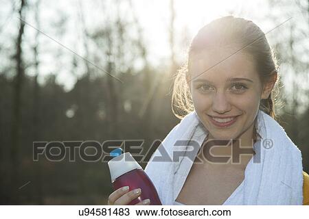 Portrait of young female runner taking a break for refreshment View Large Photo Image Stock Image - Portrait of young female runner taking a break for refreshment. Fotosearch