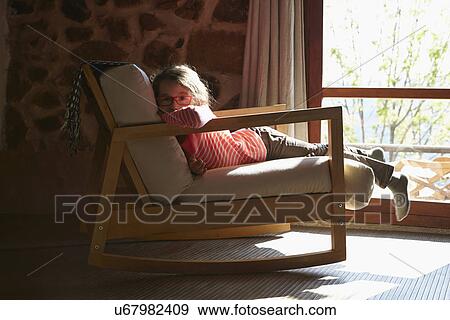 Portrait of young girl lying on rocking chair View Large Photo Image Stock Photo - Portrait of young girl lying on rocking chair. Fotosearch