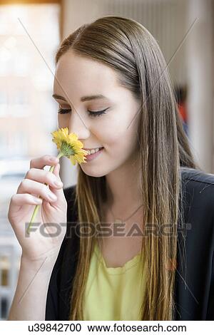 Portrait of young woman in cafe smelling flower View Large Photo Image Stock Image - Portrait of young woman in cafe smelling flower. Fotosearch