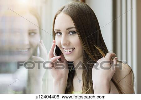 Portrait of young woman in cafe using smartphone View Large Photo Image Stock Photograph - Portrait of young woman in cafe using smartphone. Fotosearch